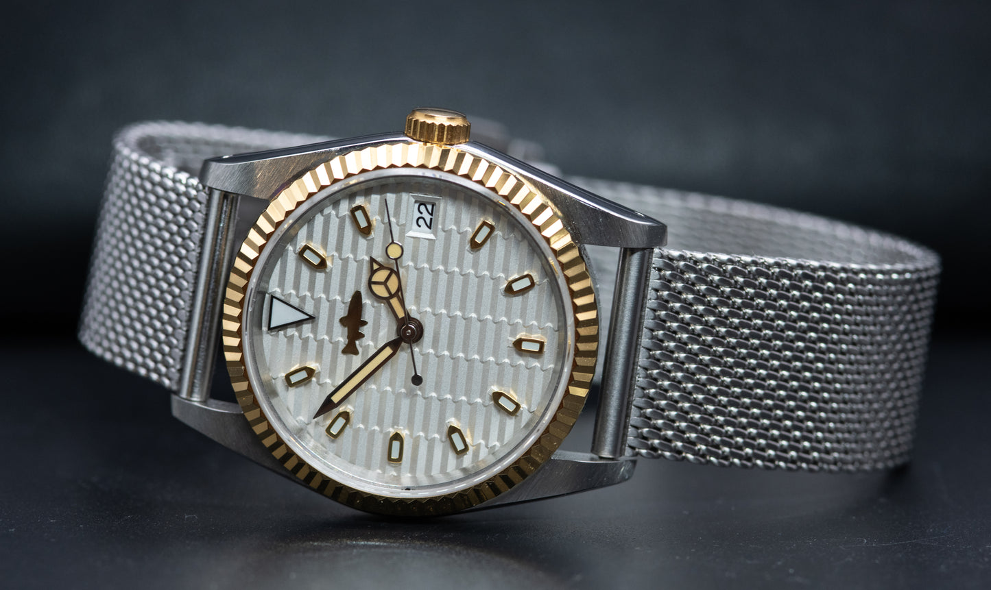 Two Tone fluted bezel watch in vintage style case. two tone fluted dial. drilled lugs. stainless steel mesh bracelet